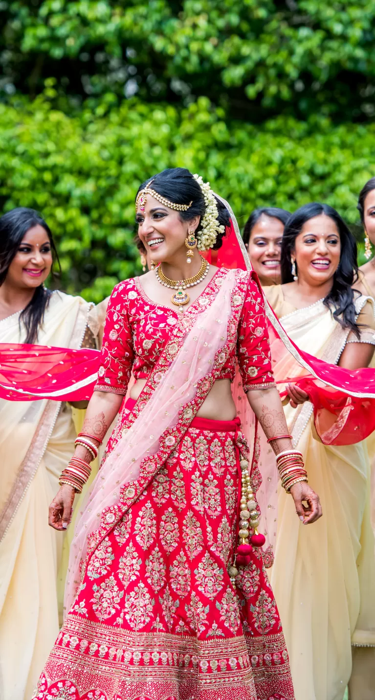A bride and her bridesmaids pose for a photo in traditional Indian attire