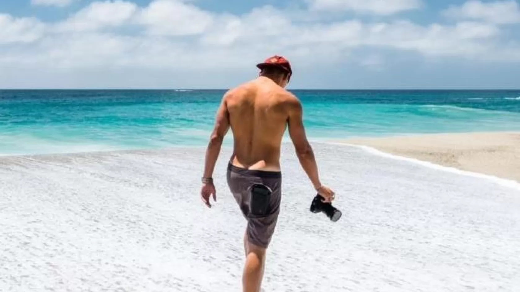 A man walks the beach with his camera