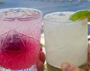 A couple holding two drinks in their hands