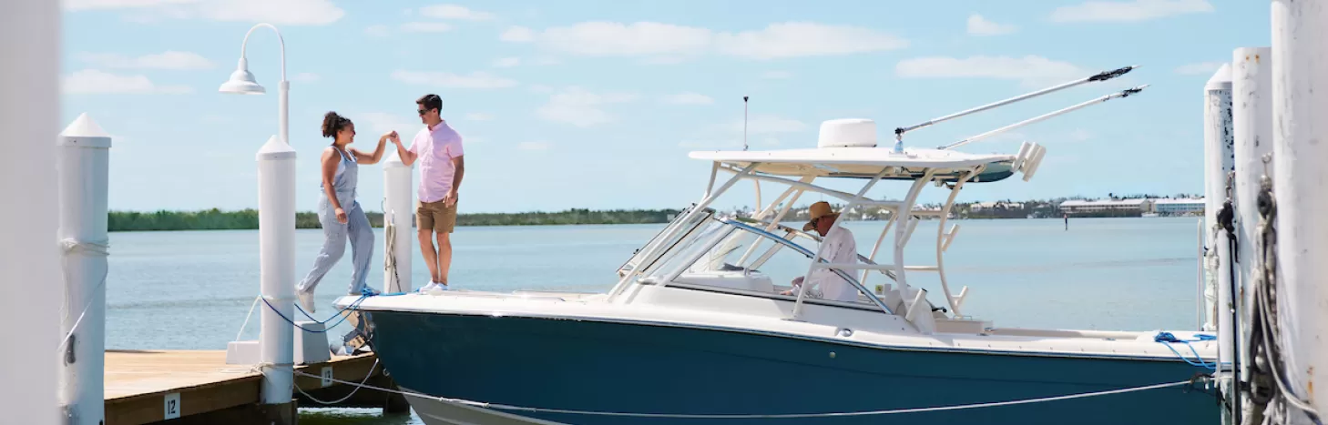 A couple boards a boat that is currently docked on Captiva Island 